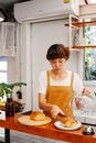 Baker putting puff on plate at cafe counter