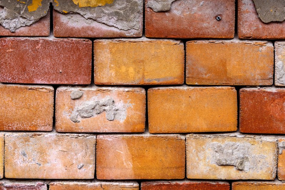 Detailed close-up of an aged brick wall, showcasing texture and construction pattern.