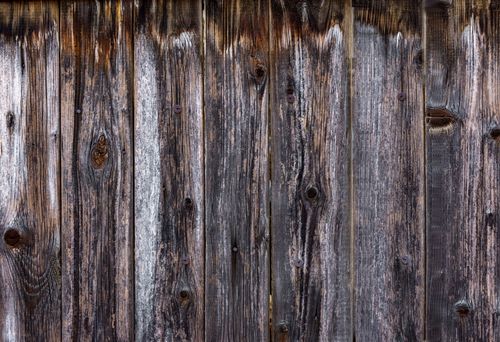 Free Close-up view of a rustic weathered wooden fence texture with detailed grain and patina. Stock Photo