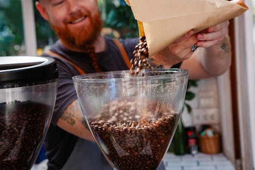 A skilled barista pouring coffee beans into a grinder at a vibrant café.