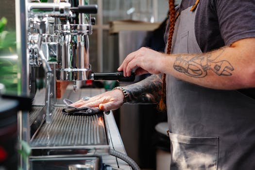 Barista preparing coffee using an espresso machine in a modern café setting.