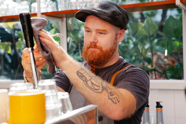 Hipster Barista Cleaning Coffee Machine In Cafe