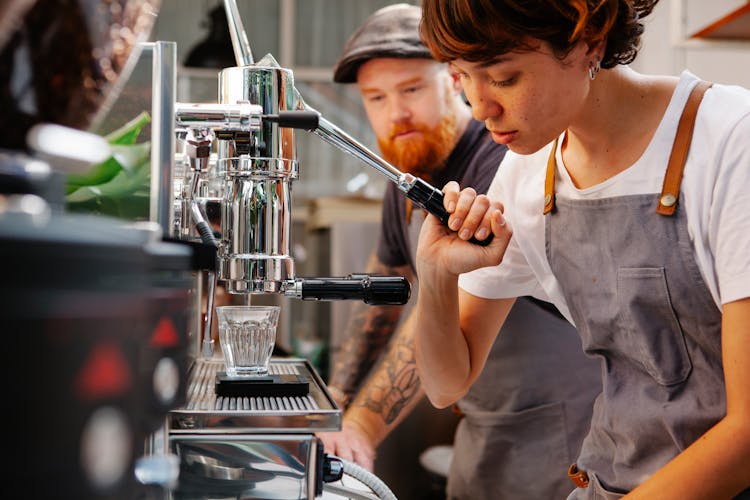 Crop Baristas With Coffee Machine In Cafe Kitchen