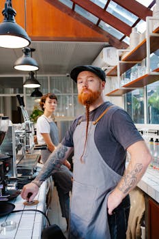 Two baristas preparing coffee in a contemporary café setting with natural light.