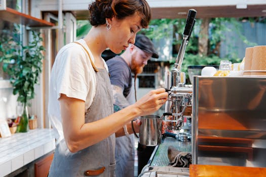 Baristas preparing espresso with a machine in a cozy, modern cafe.