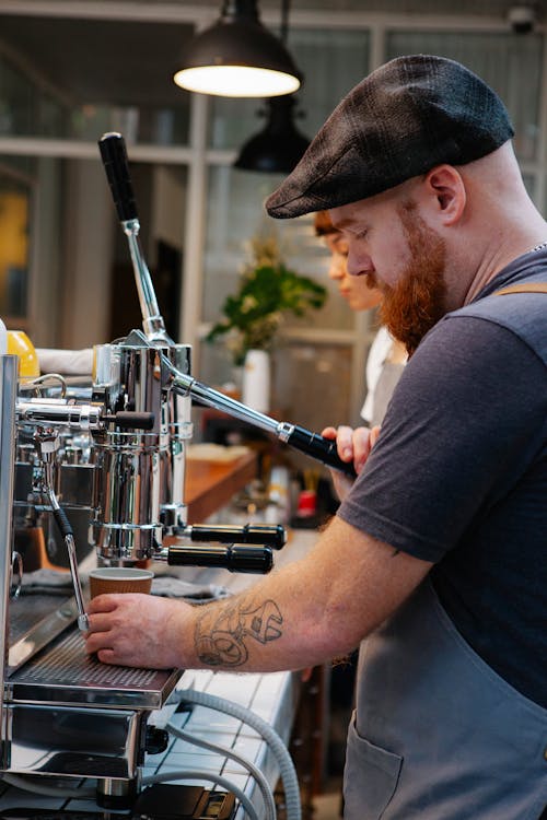 Brutal bearded bartender preparing coffee with machine