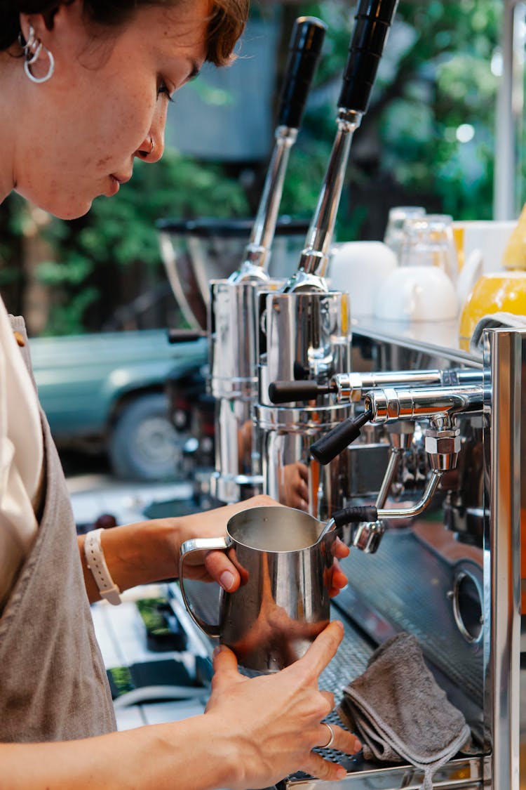 Woman Using Coffee Machine And Metal Pitcher