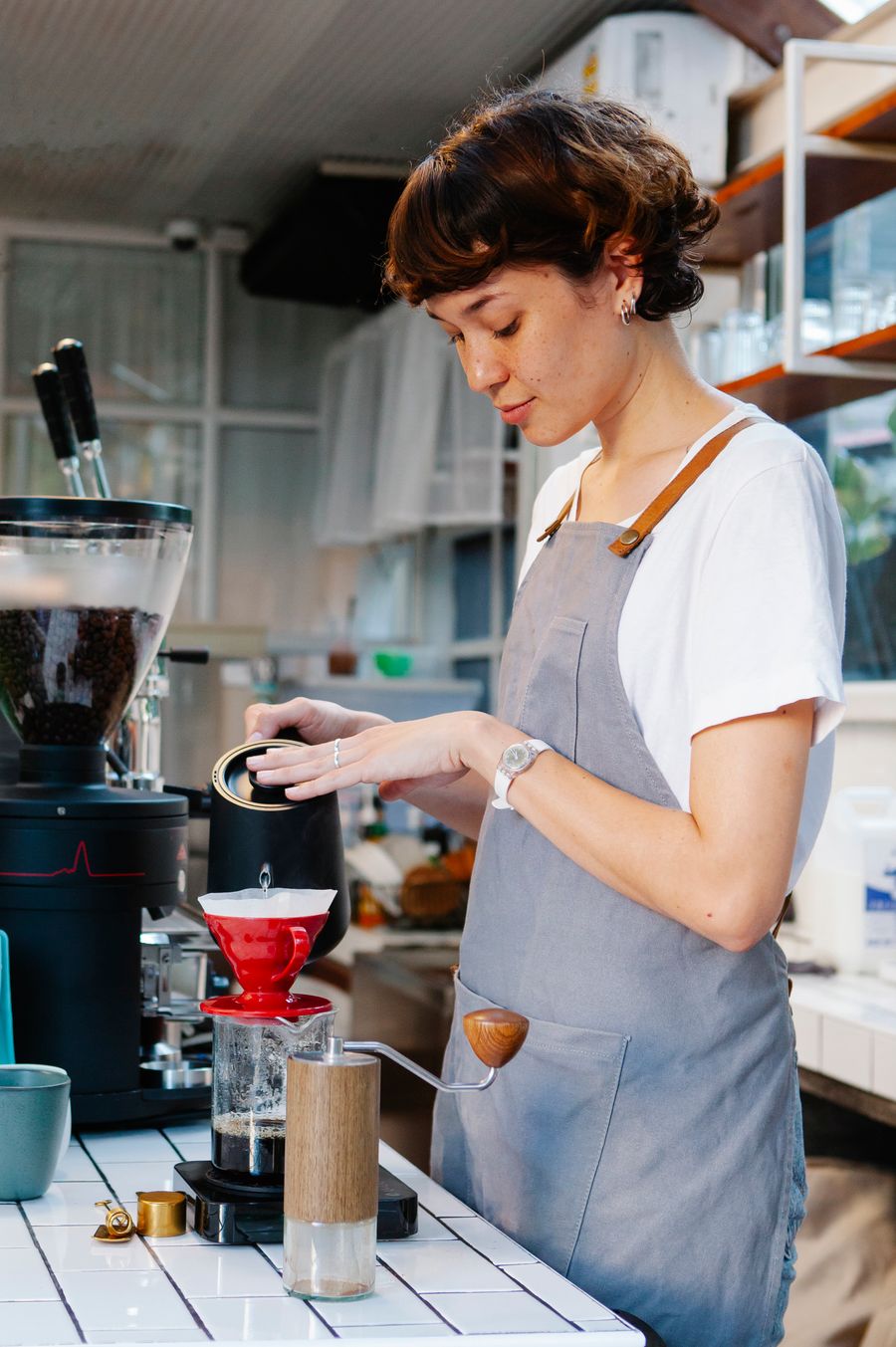 Barista brewing a pour-over at the bar, photo by Tim Douglas on Pexels