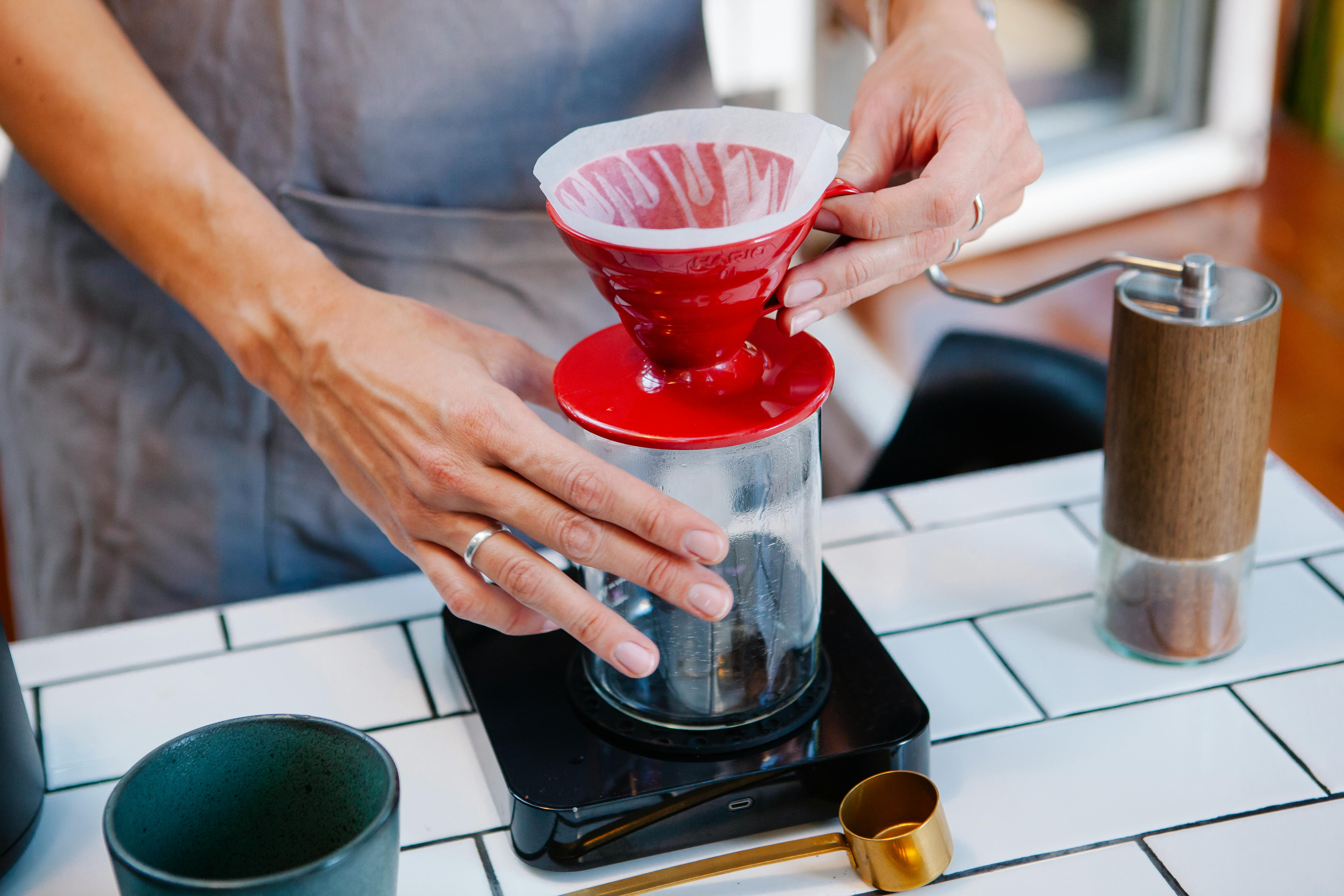 Woman barista preparing fresh alternative coffee in cafe by Tim Douglas