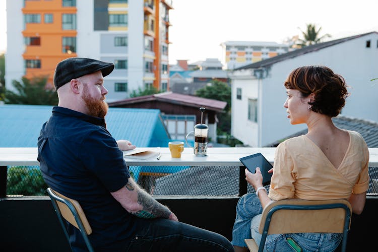 Casual Man And Woman Chatting And Resting On Terrace