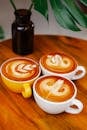 Cups of latte on wooden table