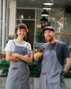 Positive coworkers in aprons on terrace of cafe