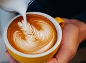 Crop barista making latte art
