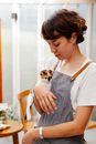 Young waitress with kitten in cafe