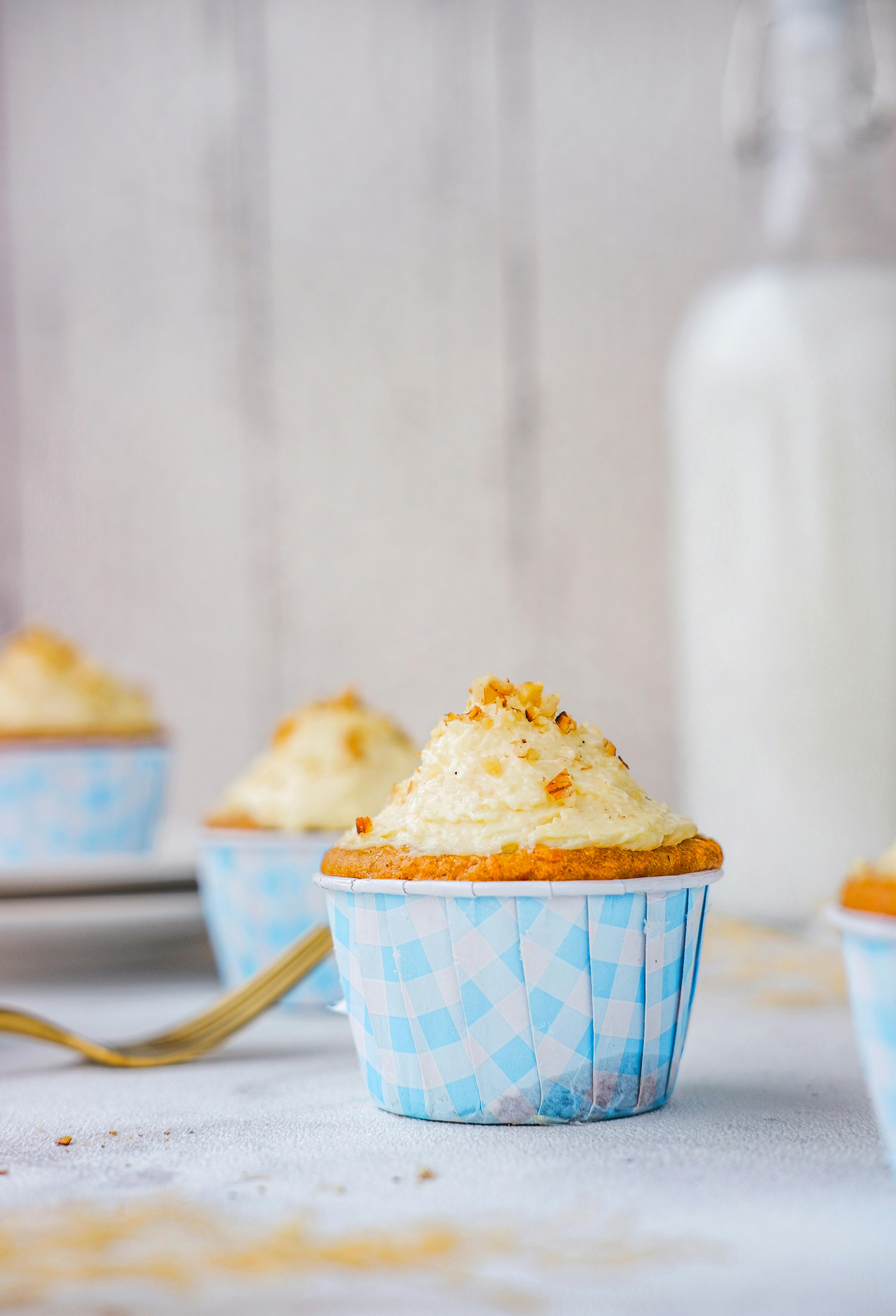 Close-up of a carrot cupcake with cream cheese frosting, highlighting its sweet, tasty appeal.