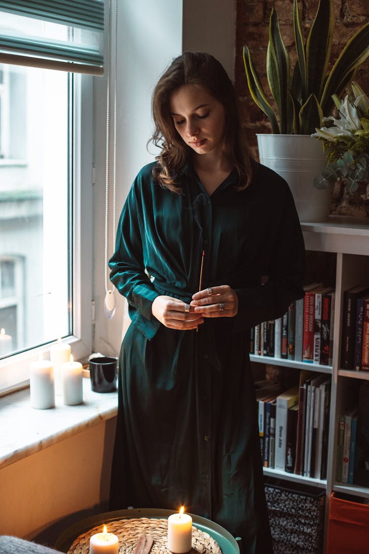 Woman In Dress Lighting Candles At Home