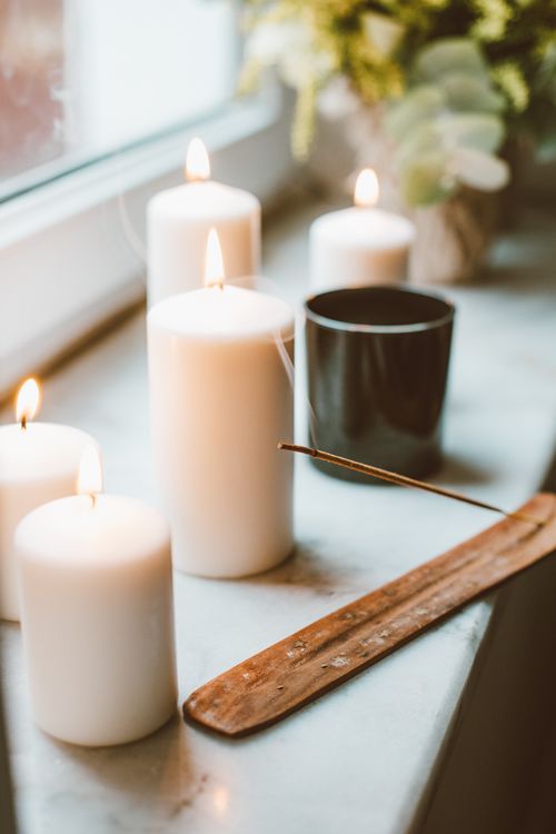 Free Warm candlelit setup with incense on a window sill creating a cozy atmosphere. Stock Photo