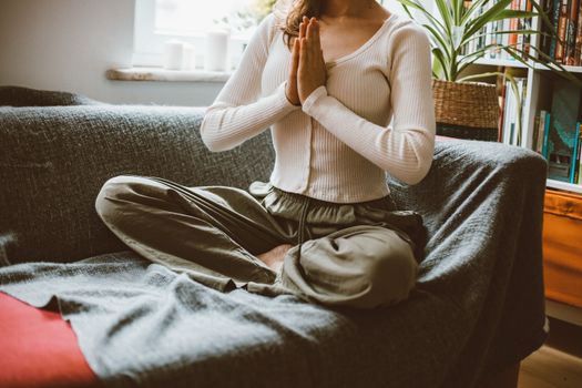 A woman practicing yoga in a cozy indoor setting, illustrating mindfulness and relaxation.
