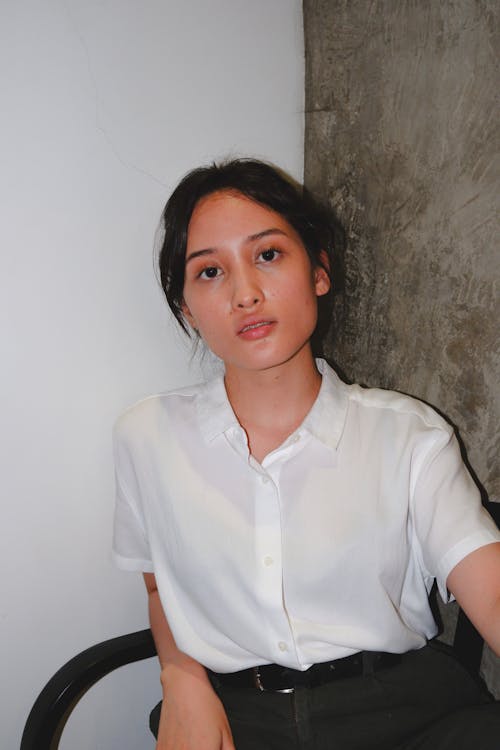 A Pretty Woman in White Button-Up Shirt Sitting