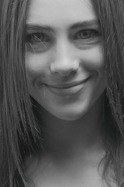 Free A grayscale portrait of a smiling woman with long hair, showcasing elegance and joy. Stock Photo