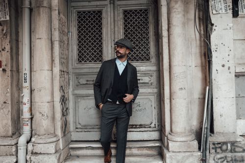 Free Confident male with beard and mustache in stylish formal clothes standing with hand in pocket against old stone building in daytime Stock Photo