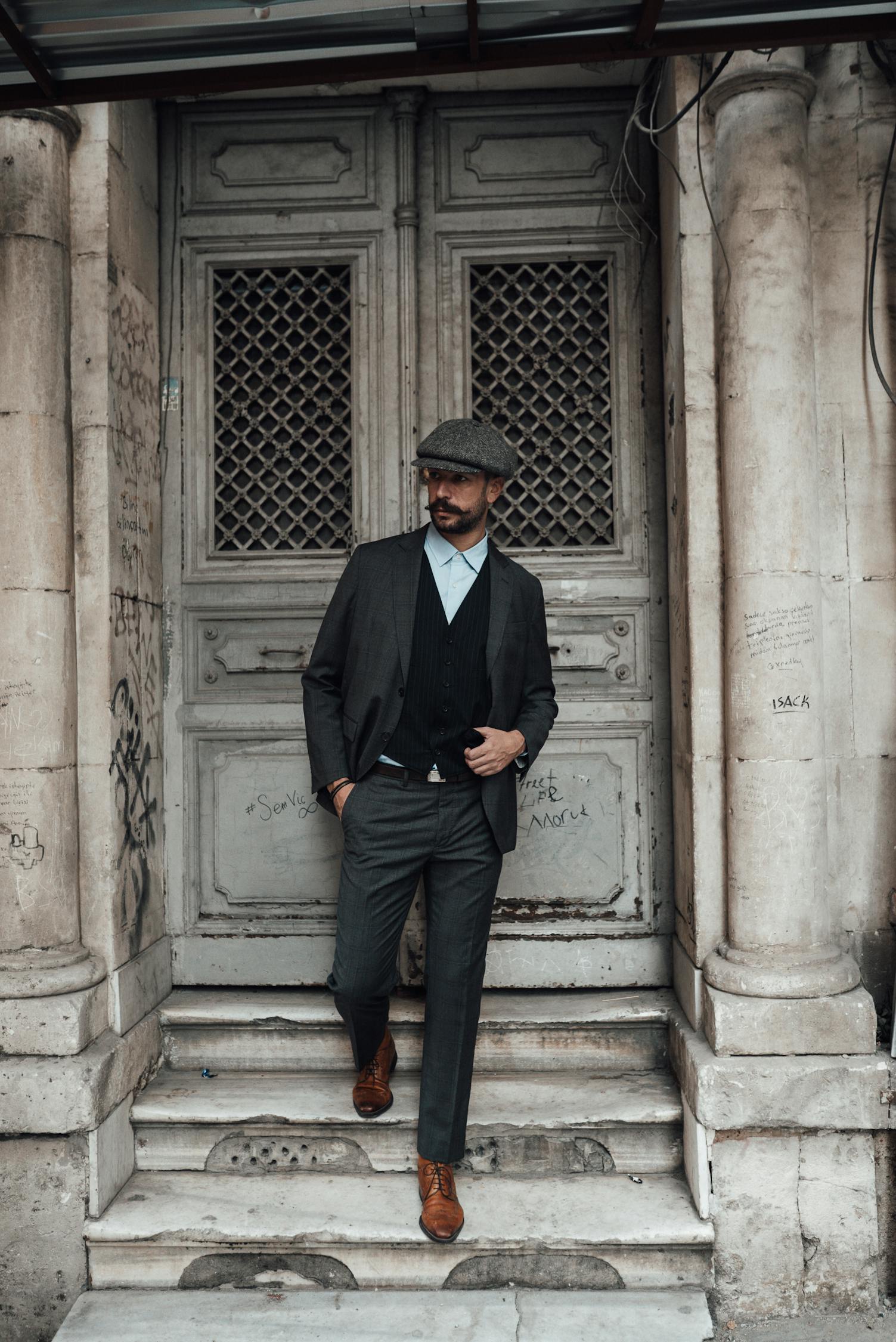 Charismatic man in suit standing near aged building · Free Stock Photo