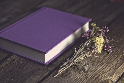 Free Close-Up Shot of a Purple Book on a Wooden Table Stock Photo