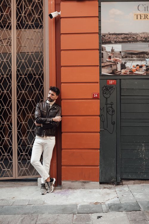Free Full body of confident male with trendy haircut and beard standing on street with crossed arms and looking away Stock Photo