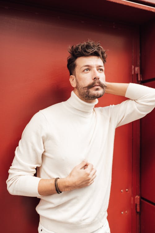 Pensive man leaning on red door