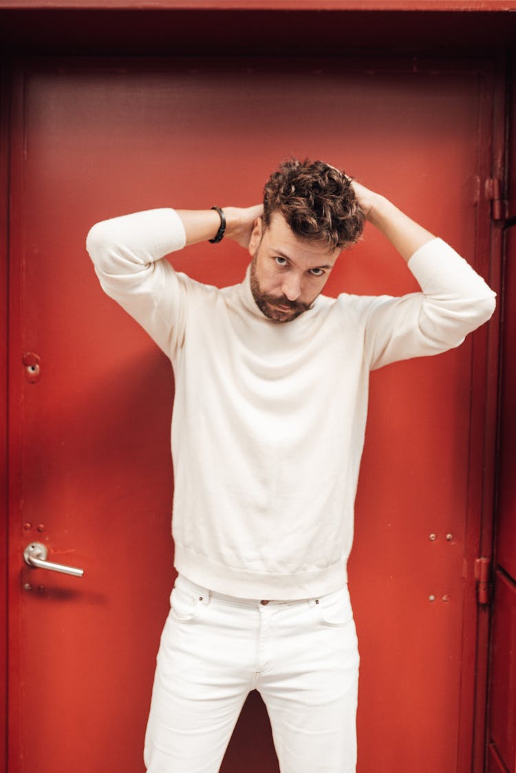 Stylish Man Fixing Hair Against Door