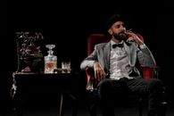 Man in Black Hat and White Dress Shirt Sitting on Red Sofa Chair