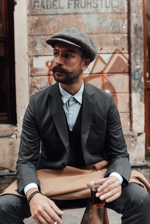 Man with mustache wearing classy outfit drinking tea on street · Free ...