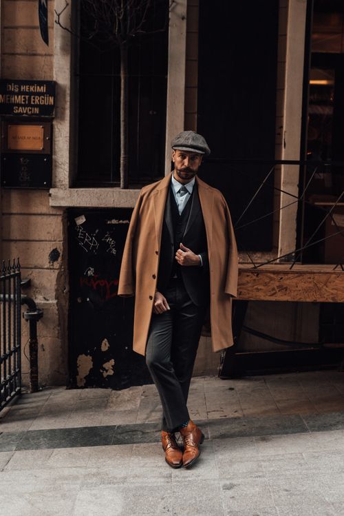 Free Full body of confident male in stylish formal clothes standing with legs crossed on city street against building in daytime Stock Photo