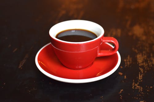 Cup of hot coffee on ceramic saucer