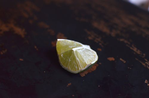 From above of piece of fresh sour citrus fruit of lemon placed in shabby surface of table