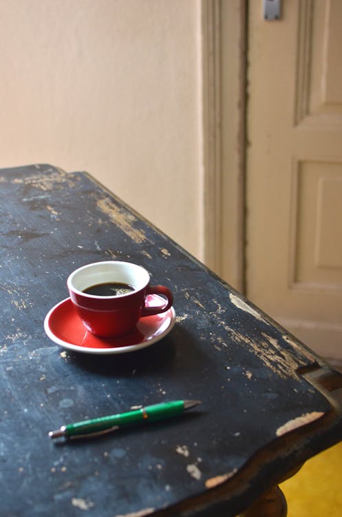 Free Pen and coffee in cup on wooden table Stock Photo