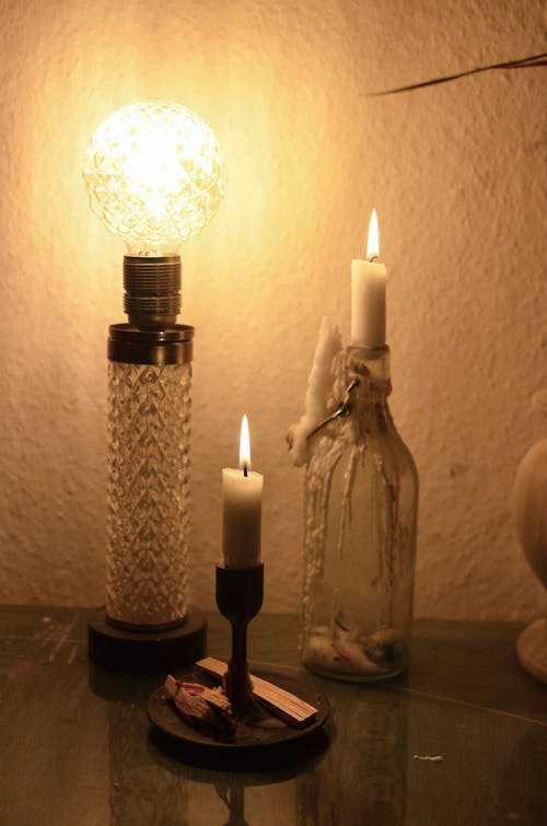 Free Lamp on table near candles and bottle Stock Photo