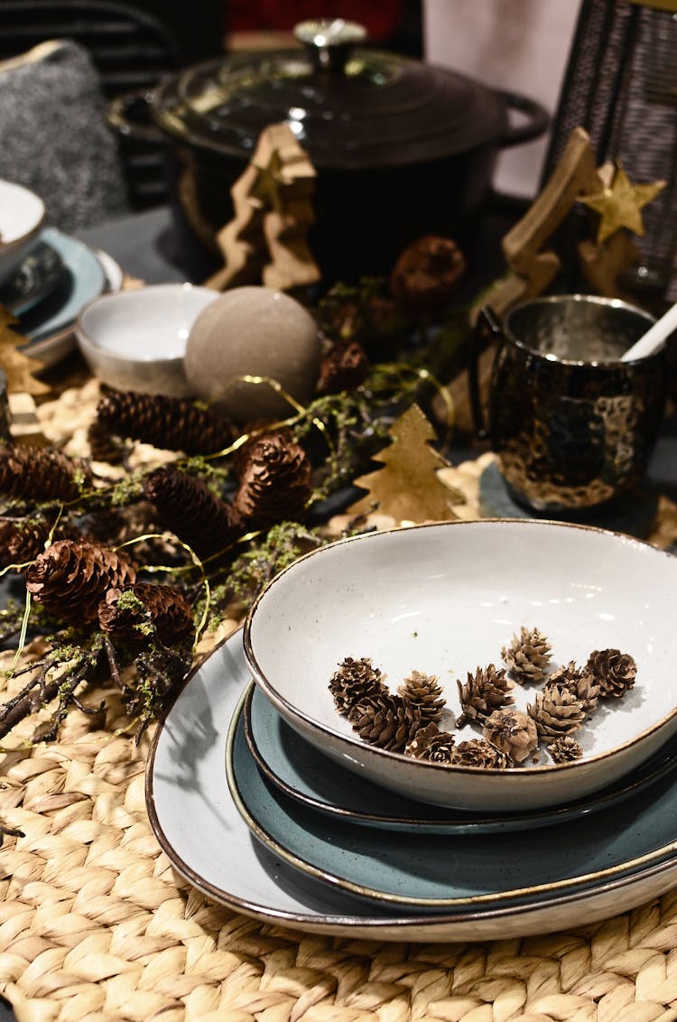 Assorted Pine Cones And Dishware On Table During Christmas Holiday