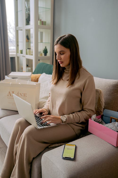 Woman Sitting on Couch Working on Laptop