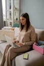 Woman Sitting on Couch Working on Laptop