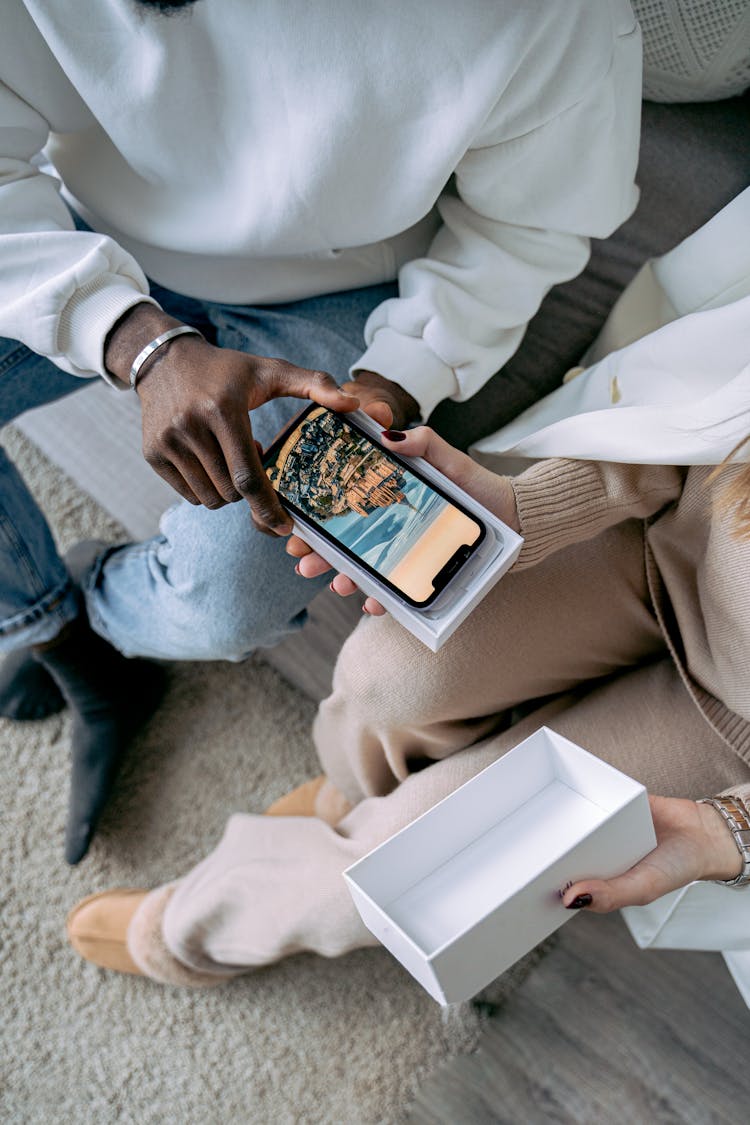 Couple Unpacking A Smart Phone From A Box