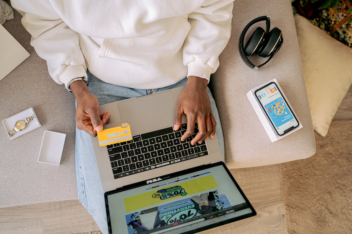 Free Woman Sitting on a Couch and Online Shopping Stock Photo