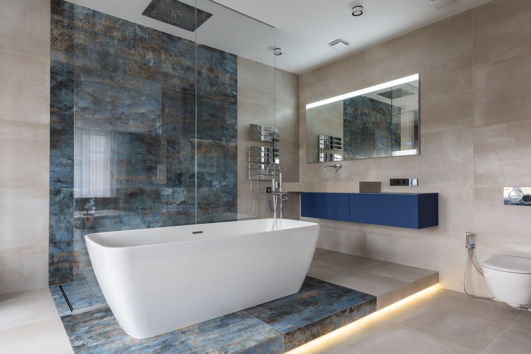 Modern bathroom with freestanding bathtub, clean stone surfaces and simple contemporary fittings