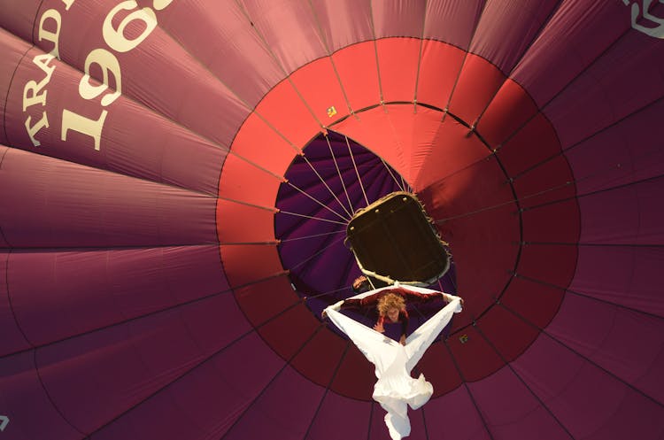 Acrobat Suspended From A Balloon And Performing An Aerial Dance