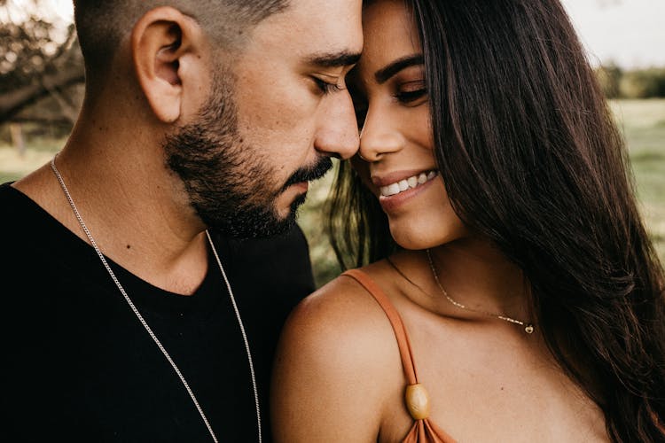 Crop Hispanic Couple Touching Noses In Countryside Field