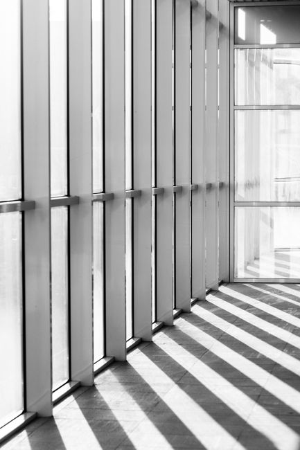 Empty loft hallway of contemporary multistorey building with glass walls in bright sunlight