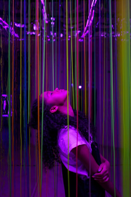 Girl Standing between Illuminated Colorful Lines 