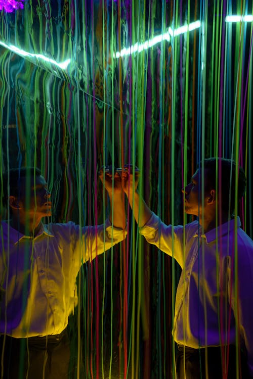 Photograph of a Man with Writing Near Colorful Threads