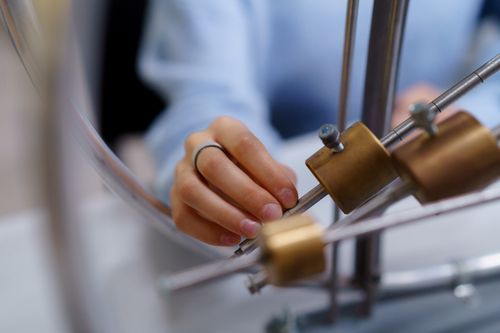 Free Close-up of a student's hand interacting with physics lab equipment for learning. Stock Photo