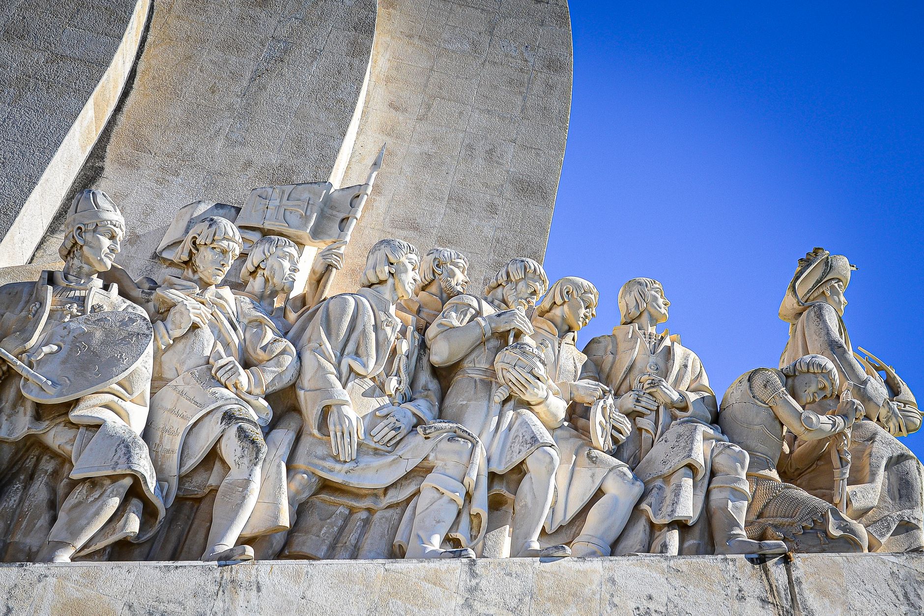 Intricate stone sculptures of historical figures at the Monument to the Discoveries in Lisbon.